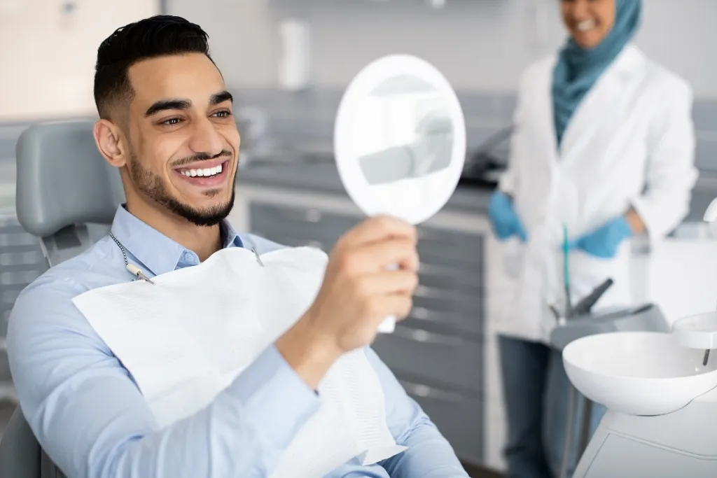 Man looking into mirror and smiling