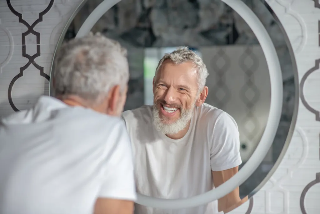 Old man smiling in mirror