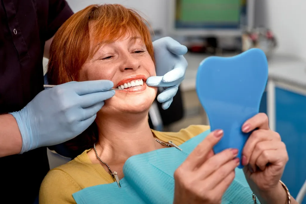 Woman looking at teeth with dentist