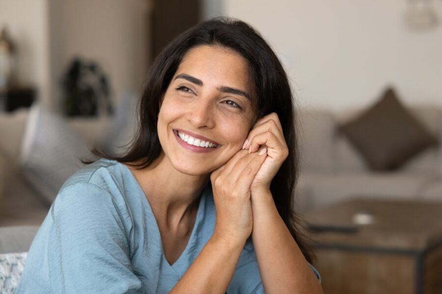 Smiling woman representing confidence with implant-supported dentures in Bethesda, MD