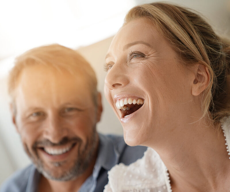 Smiling couple representing confidence after front tooth replacement in Bethesda, MD