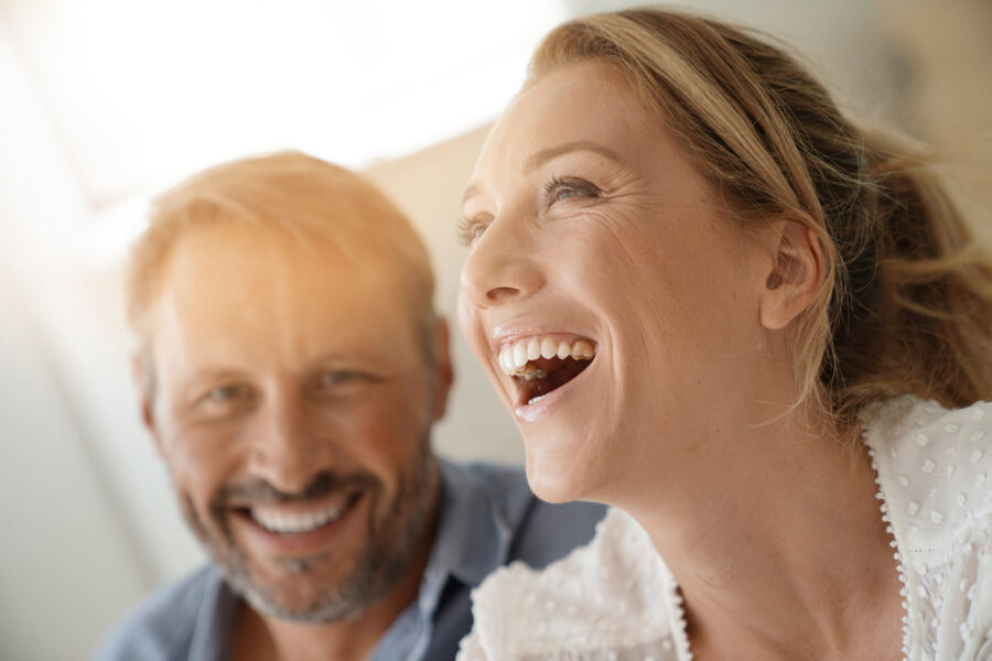 Smiling couple representing confidence after front tooth replacement in Bethesda, MD