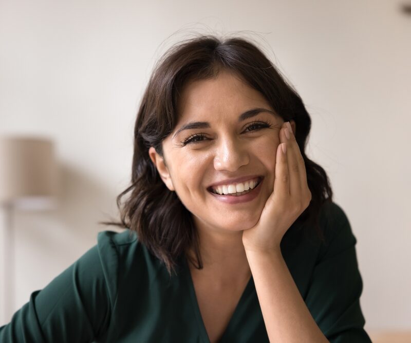 Smiling woman showing a complete, natural-looking smile after full-arch dental implant treatment in Bethesda, MD