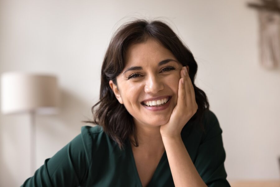 Smiling woman showing a complete, natural-looking smile after full-arch dental implant treatment in Bethesda, MD