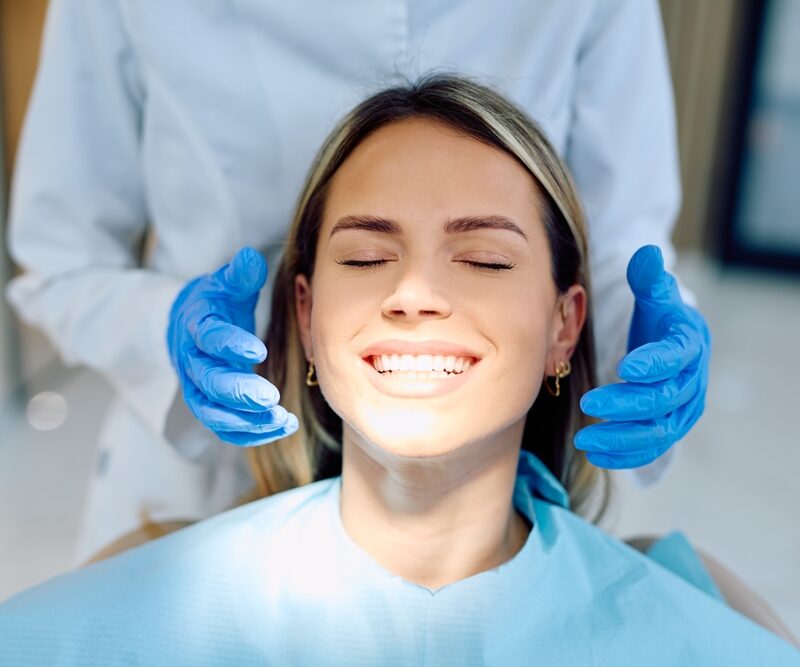 Smiling female patient during a restorative dental examination at a practice in Bethesda, MD