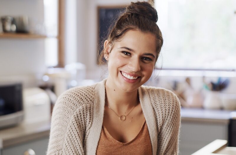 Smiling young woman showing healthy-looking teeth after conservative white spot lesion treatment in Bethesda, MD