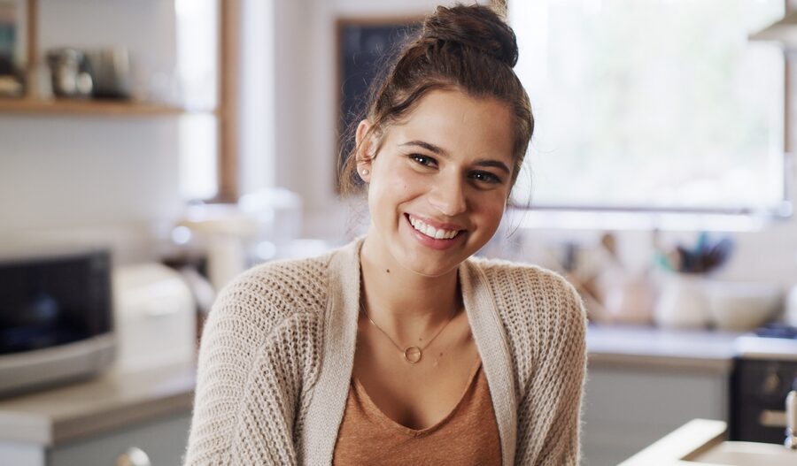 Smiling young woman showing healthy-looking teeth after conservative white spot lesion treatment in Bethesda, MD