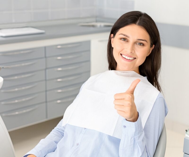 Smiling dental patient giving a thumbs-up after implant preparation in Bethesda, MD