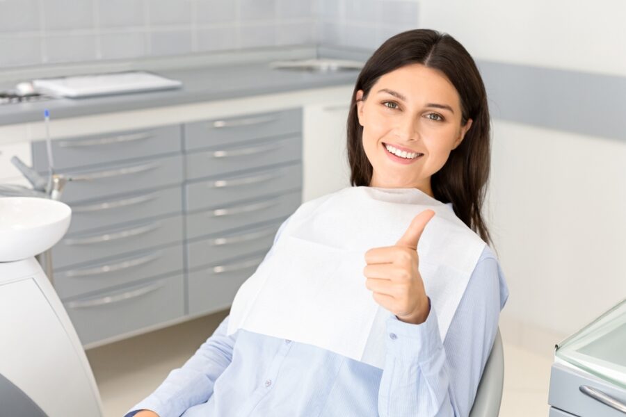 Smiling dental patient giving a thumbs-up after implant preparation in Bethesda, MD